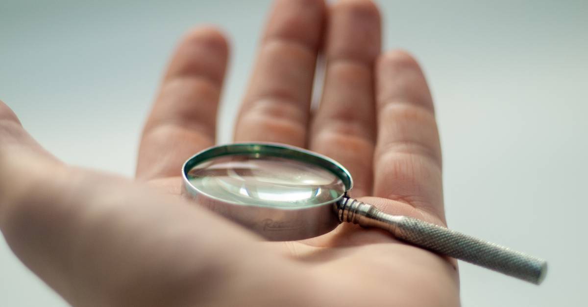 Magnifying glass in hand illustrating to focus on evidence