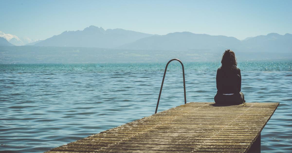 Women alone looking at lake illustrating thinking