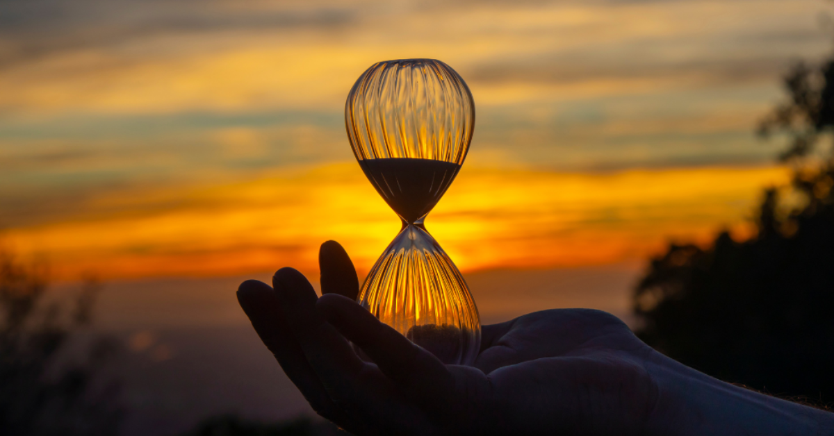 Sand timer in-front of sunset_Three Ways to Navigate Tough Times_Blog, by Owen O'Kane.